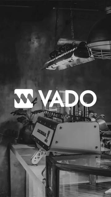 Zwart-witbeeld van de espressomachine bij VADO met het VADO-logo.