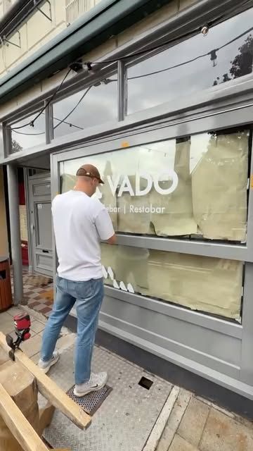 De nieuwe VADO-raamstickers worden op de gevel aan de Oosterwal geplakt.
